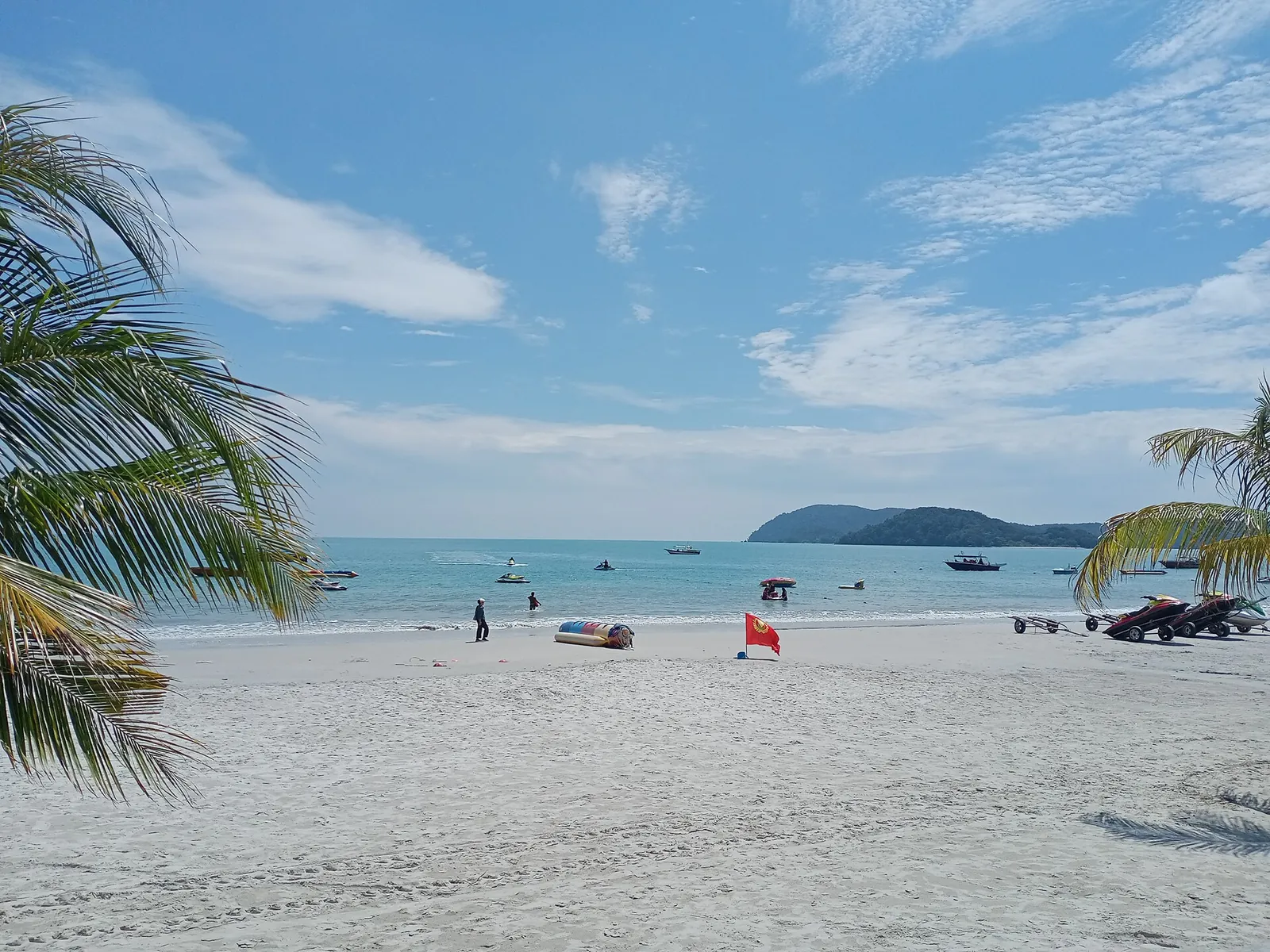 Udsigt over Pantai Cenang-stranden på Langkawi indrammet af palmer