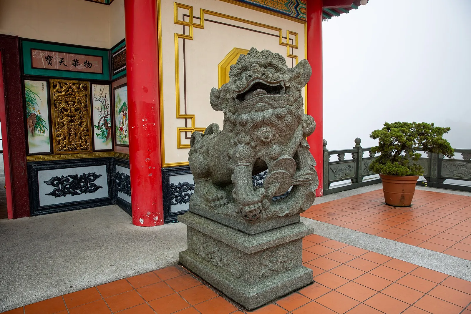 Stone guardian lion and decorated pavilion at Chin Swee Caves Temple