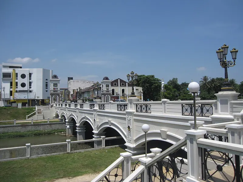 Decorative bridge across the Kinta River with Ipoh buildings behind it