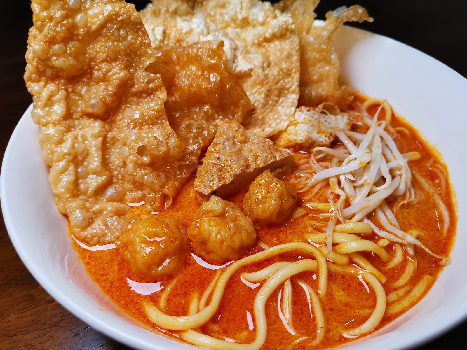 Bowl of Foon Yew laksa with noodles, bean sprouts and fried toppings