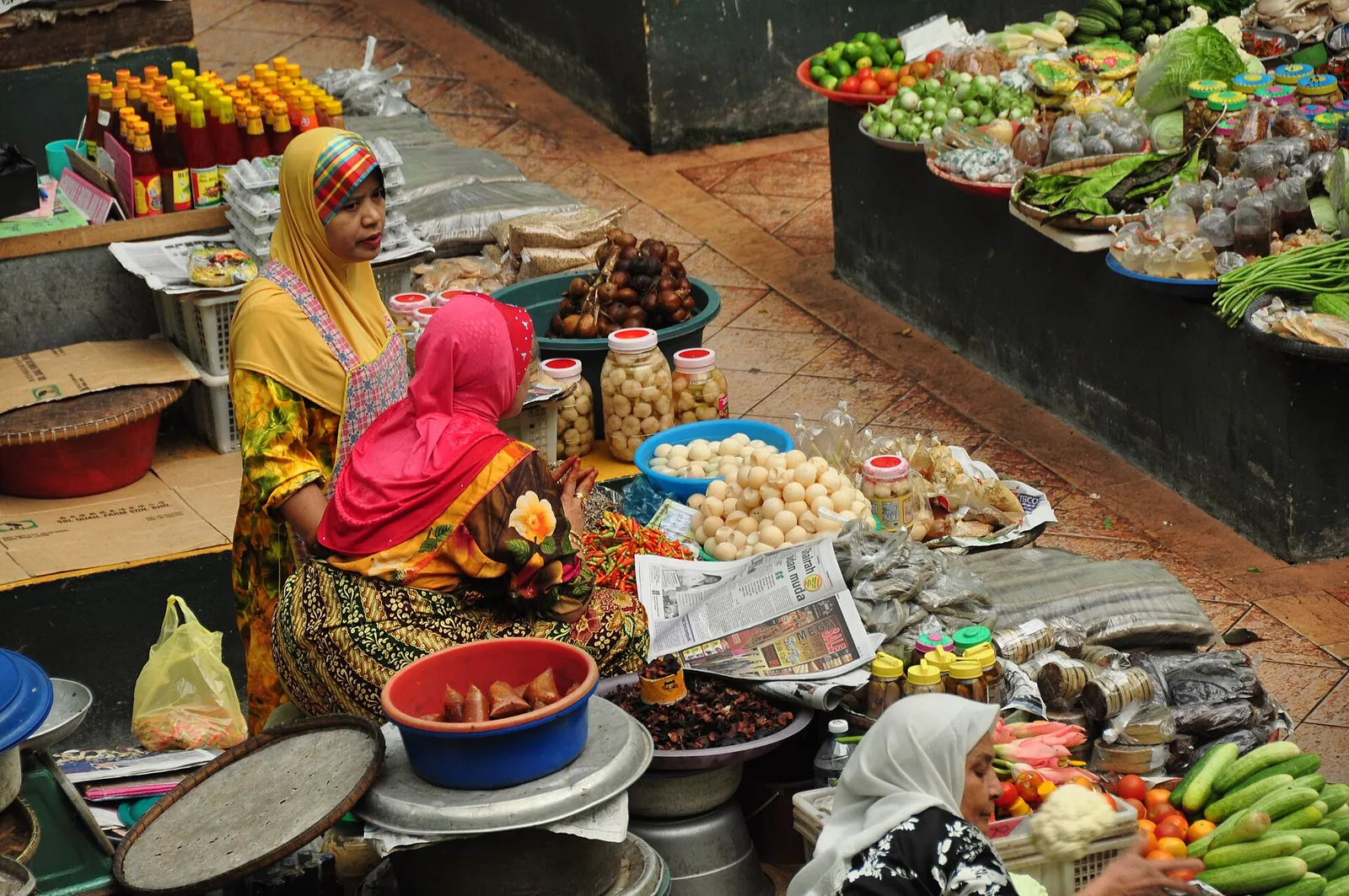 Vendors and baskets of vegetables inside Siti Khadijah Market