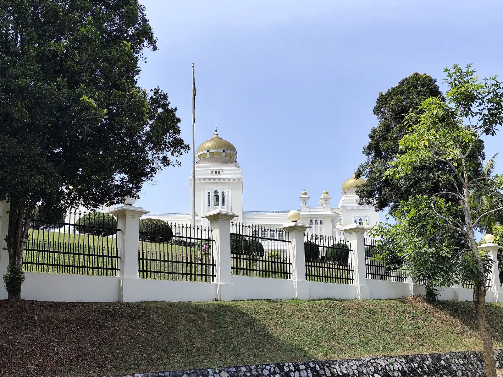 Istana Iskandariah behind its fence and trees in Kuala Kangsar