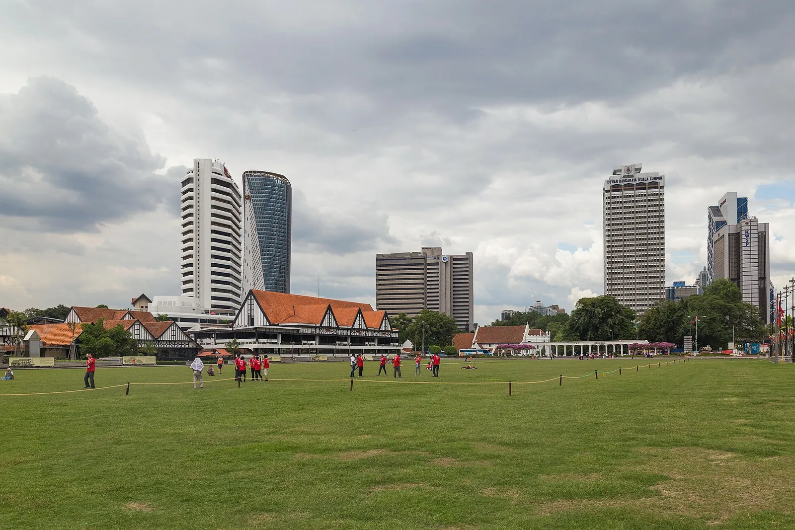 The broad green lawn at Dataran Merdeka facing Kuala Lumpur buildings