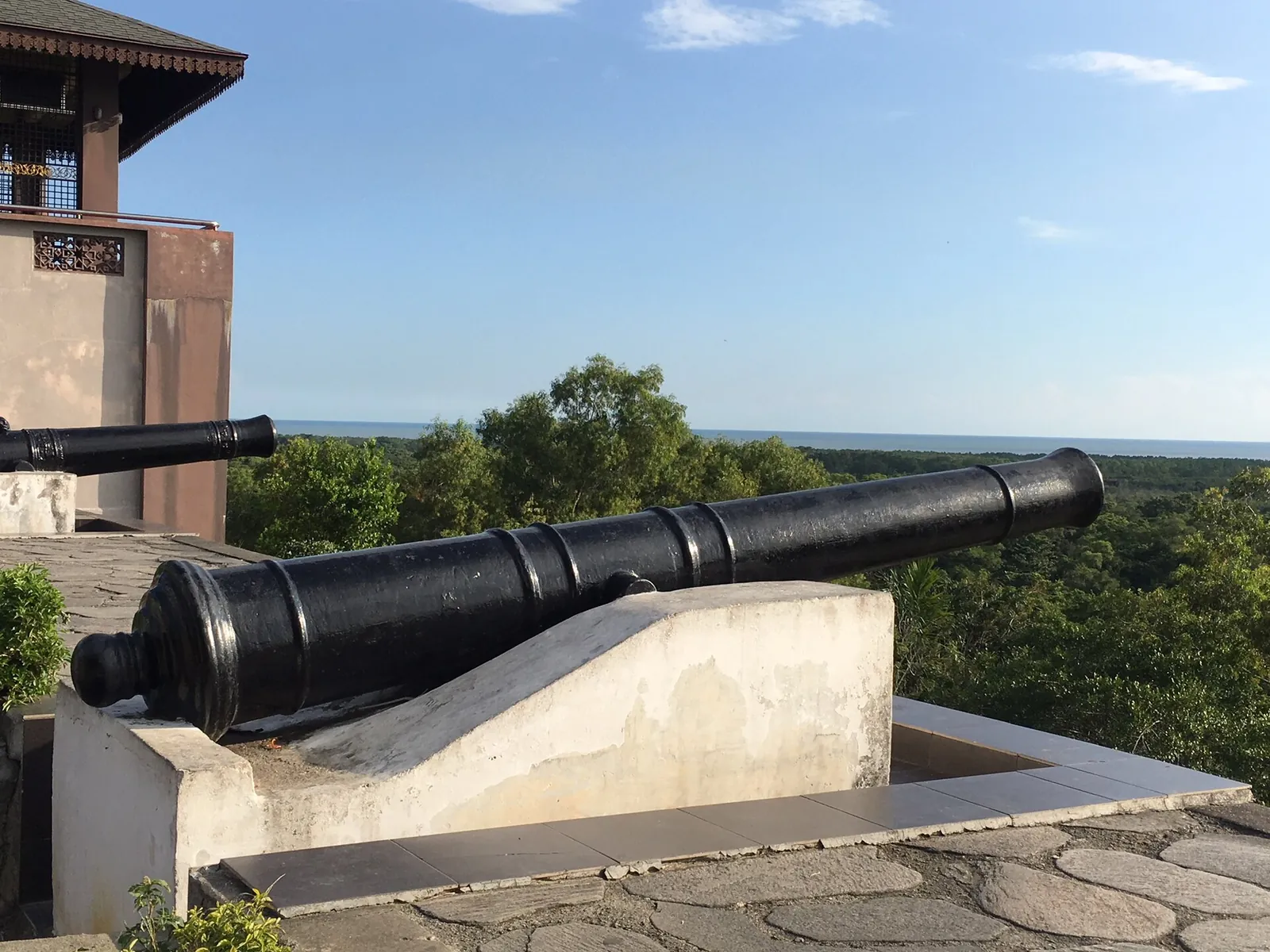 Historic cannon on Bukit Melawati with the Strait of Malacca beyond
