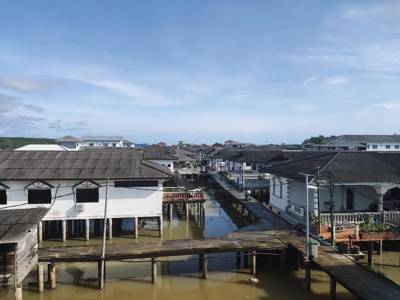 Stilt houses and raised walkways above tidal water in Kukup Laut