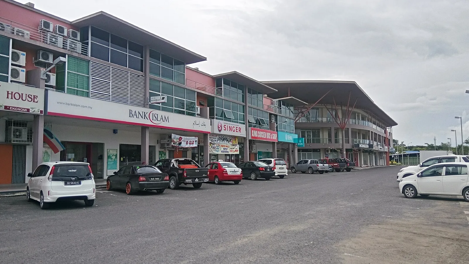 Rows of modern shophouses beside a broad street in Harbour Town, Lahad Datu