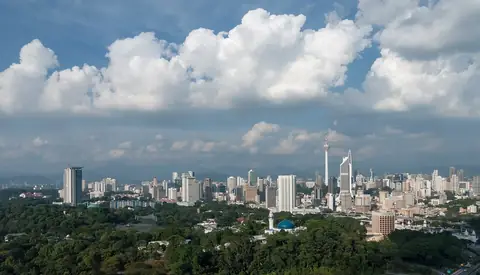 Kuala Lumpur breder sig under høje eftermiddagsskyer og en lys tropisk himmel.