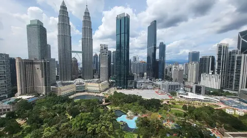 Petronas Twin Towers og Kuala Lumpurs skyline over KLCC Park i dagslys