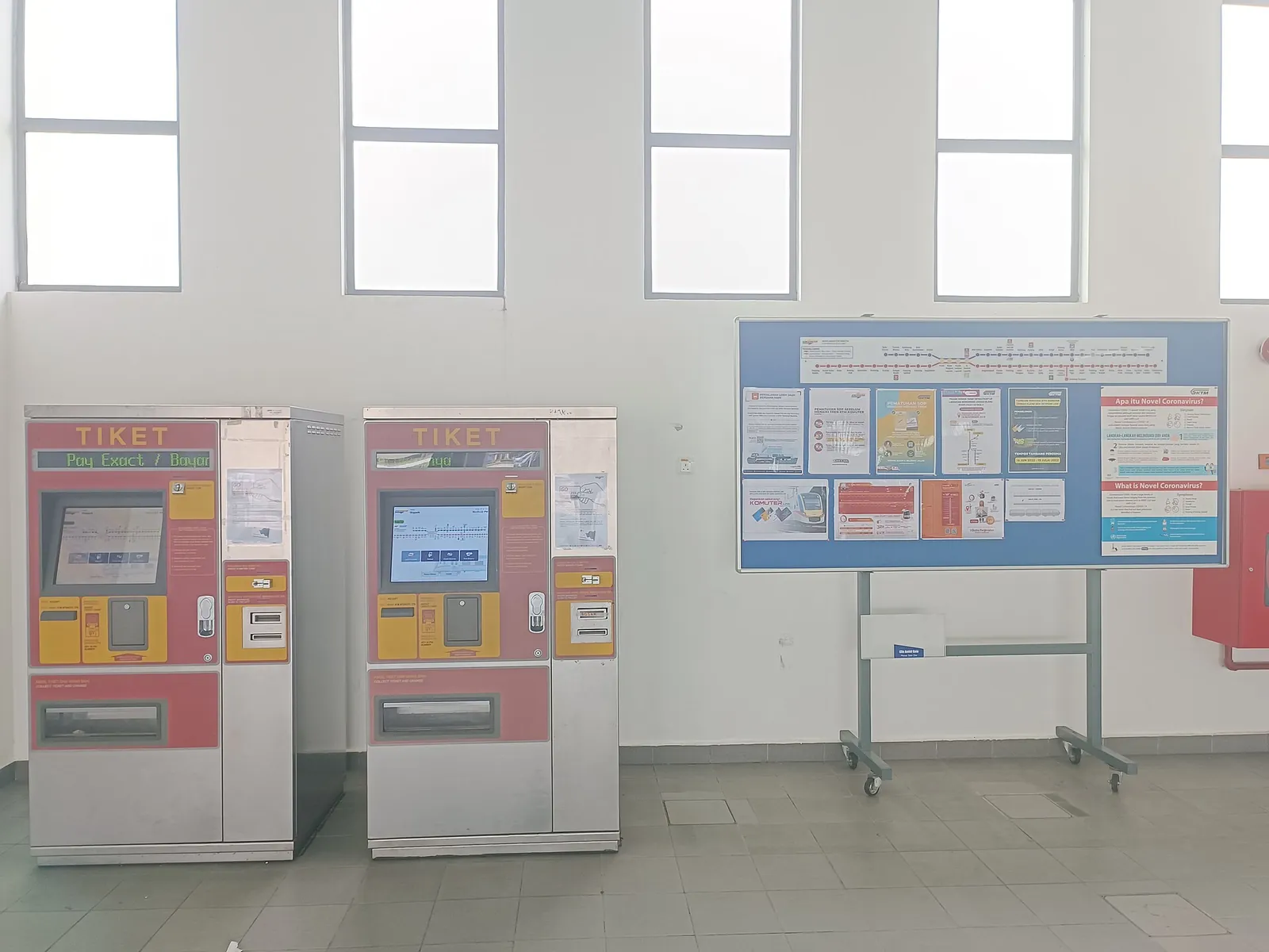 Ticket vending machines below tall windows at Terminal Skypark KTM station