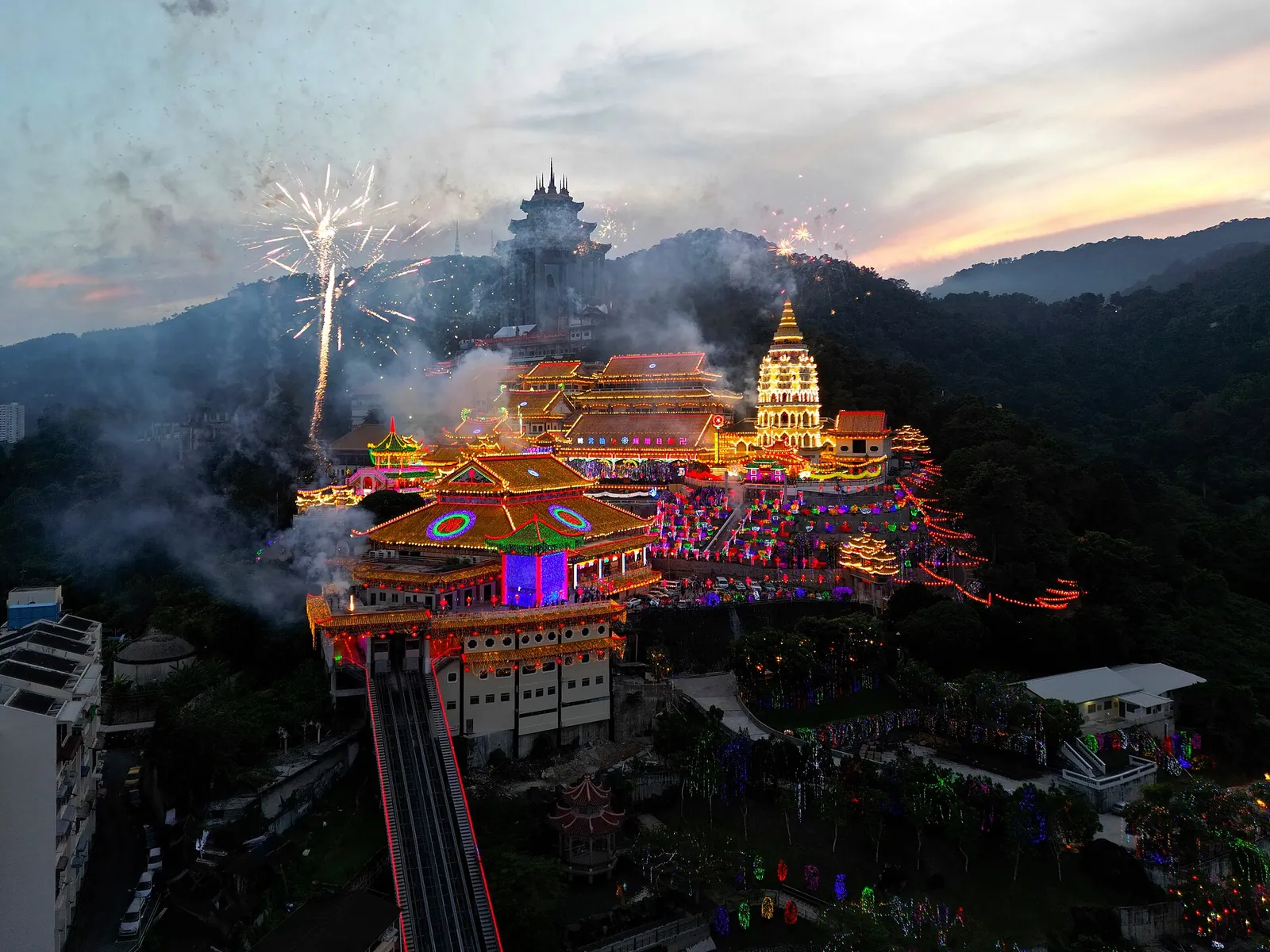 Kek Lok Si illuminated with colourful lights and fireworks near sunset