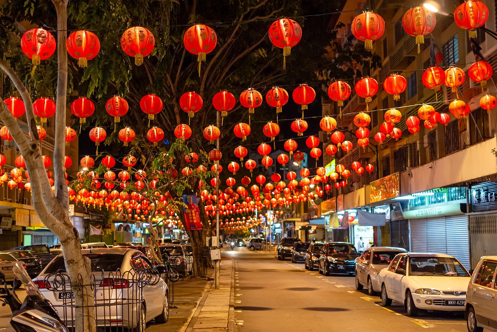 Red Chinese New Year lanterns strung above Gaya Street at night