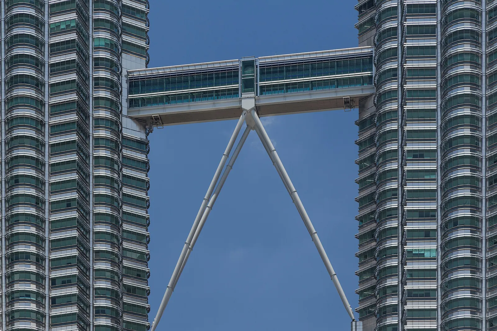 The skybridge linking the two Petronas Towers against a blue sky in Kuala Lumpur