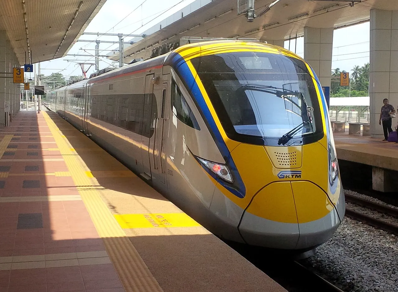 A yellow and blue KTM ETS electric train at a station platform