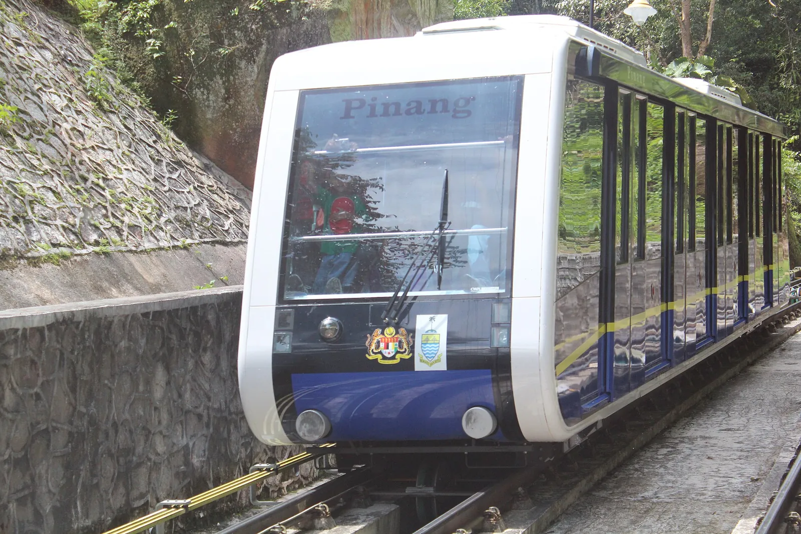 A Penang Hill funicular car on the steep track among trees