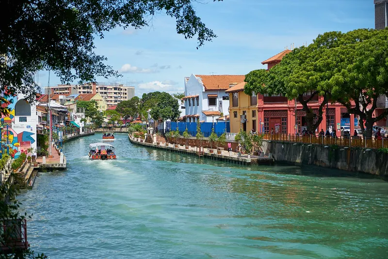 Malacca River beside colorful riverside buildings and trees