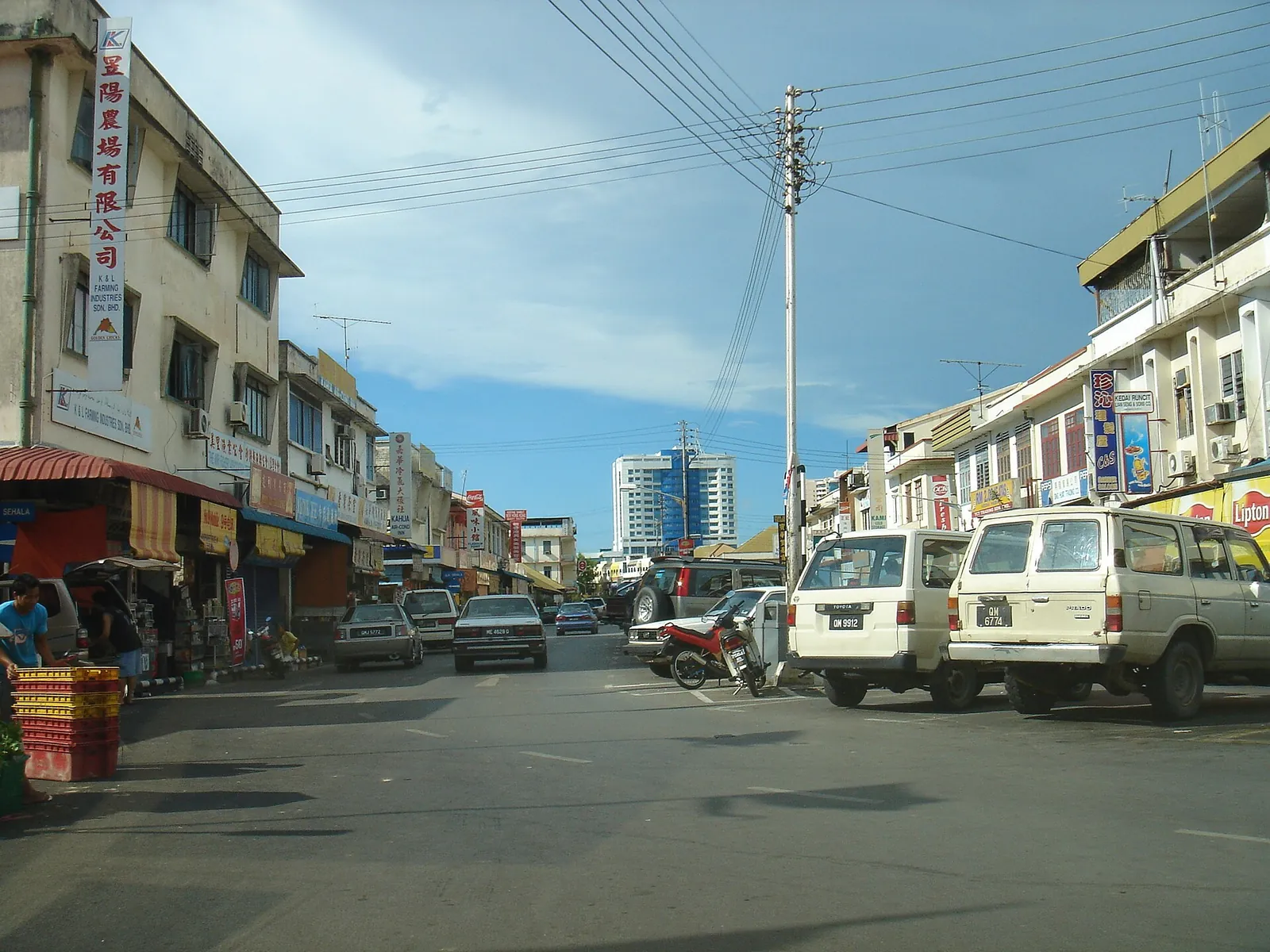 Shophouses, vehicles and a blue sky in an older section of Miri