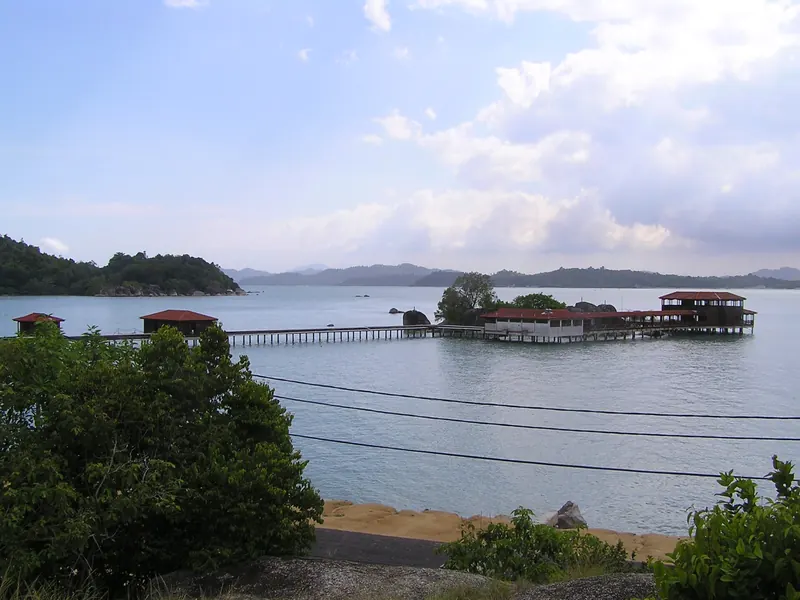 Coastal bay with wooden structures and forested hills on Pangkor Island