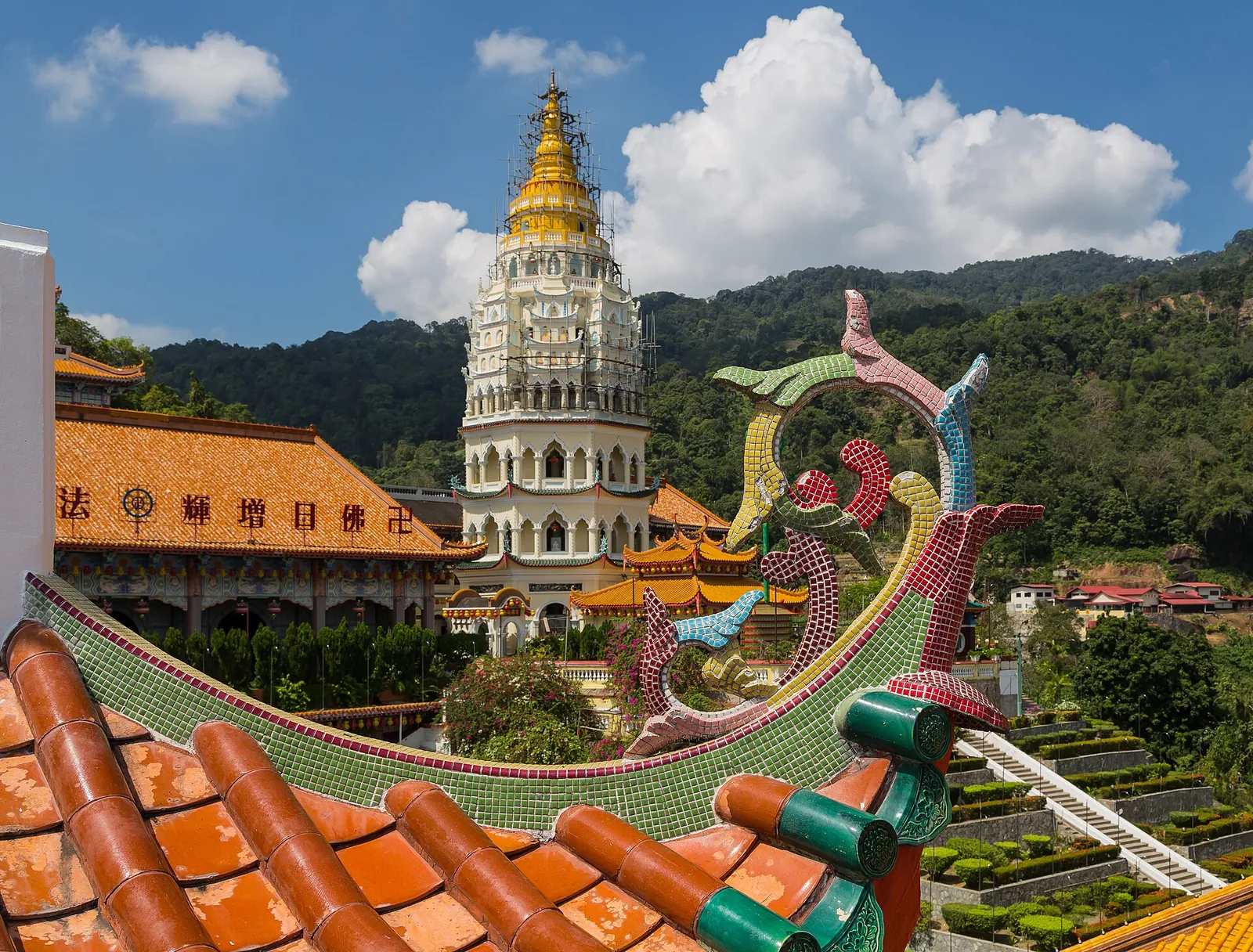 Kek Lok Si pagoda and temple rooftops with green hills and blue sky in Penang