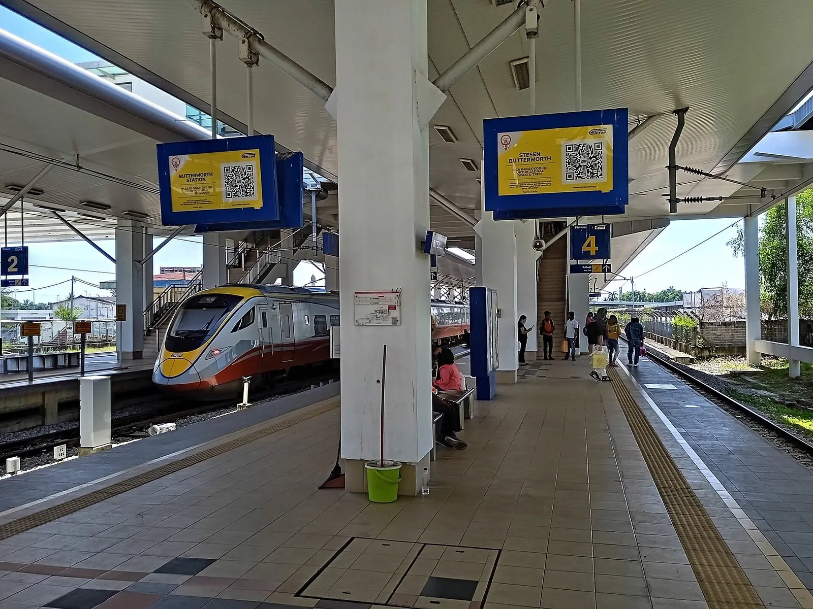 Pociąg ETS na peronie stacji Butterworth pod długim dachem peronu, z oczekującymi podróżnymi