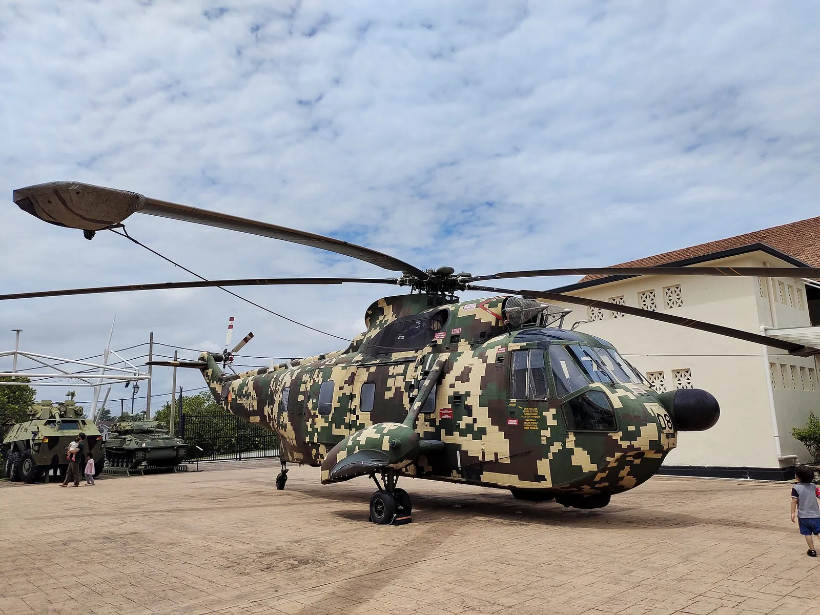 Camouflaged helicopter displayed outdoors at the Army Museum in Port Dickson