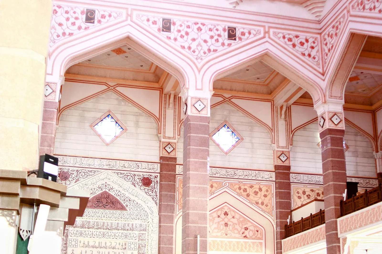 Pale pink arches and geometric ornament inside Putra Mosque in Putrajaya