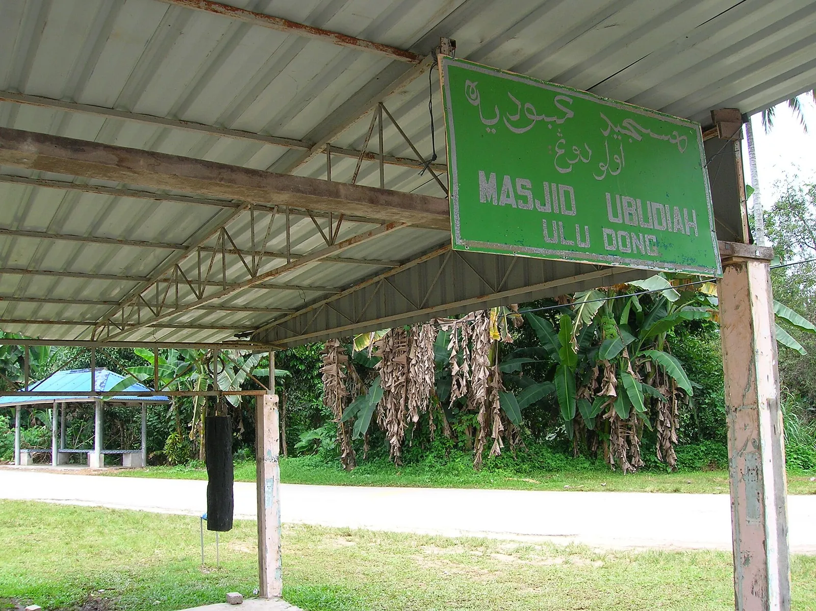 Green mosque sign and covered entrance walkway at Masjid Ubudiah in Ulu Dong