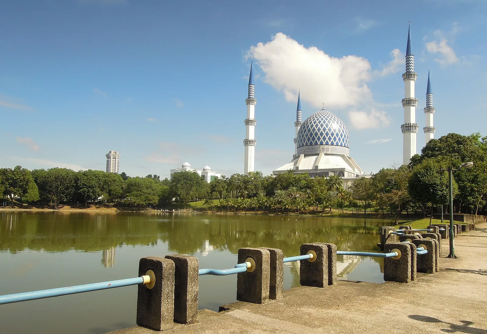Blue dome and minarets of Sultan Salahuddin Abdul Aziz Mosque across a lake in Shah Alam