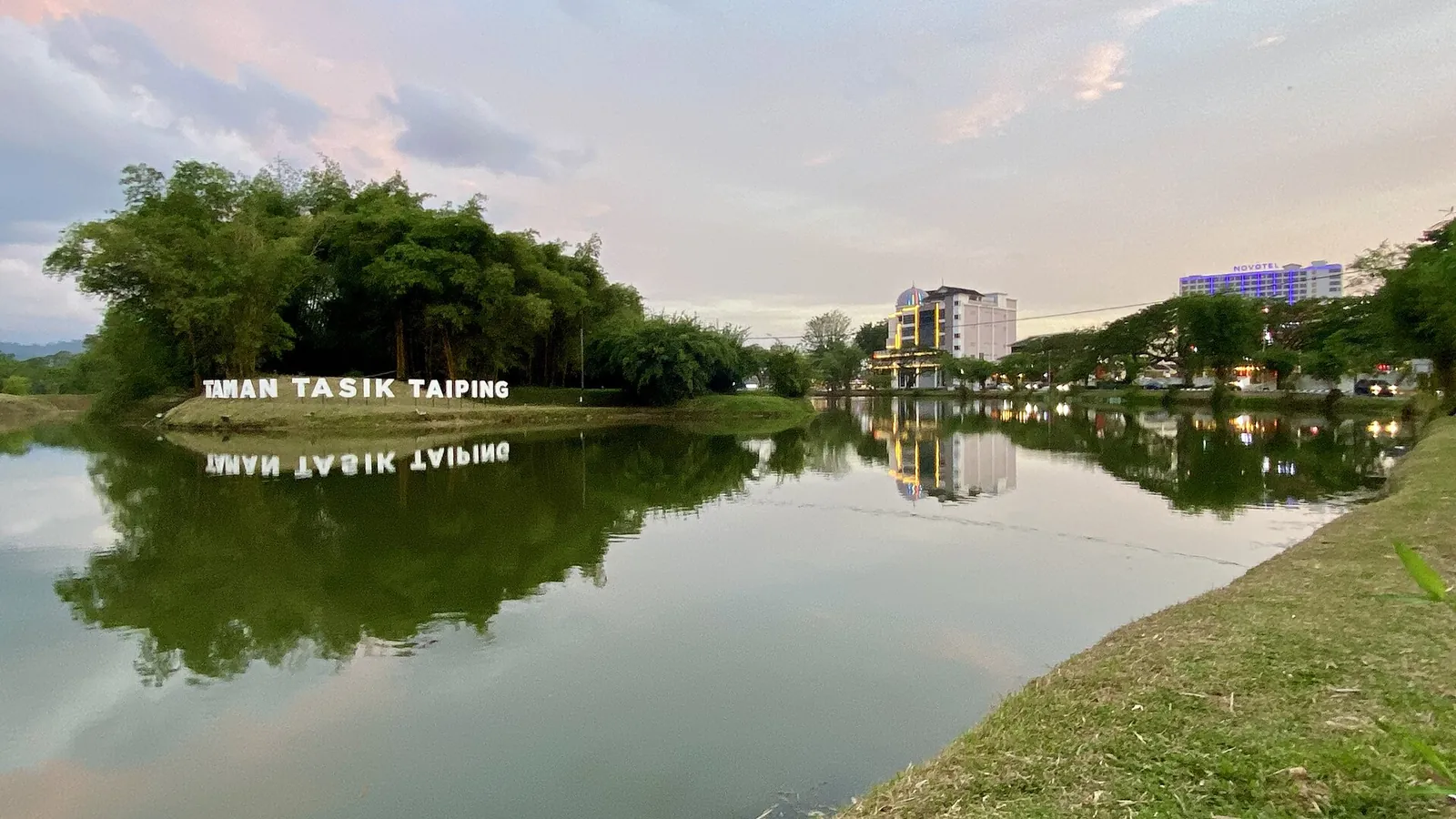 Lake Gardens sign reflected in still water at Taiping at dusk