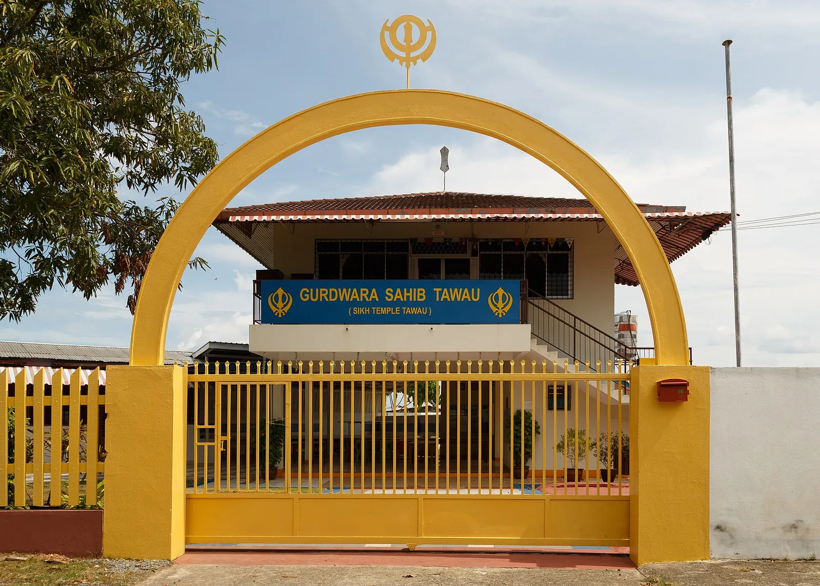 A yellow entrance arch and building at Gurdwara Sahib in Tawau