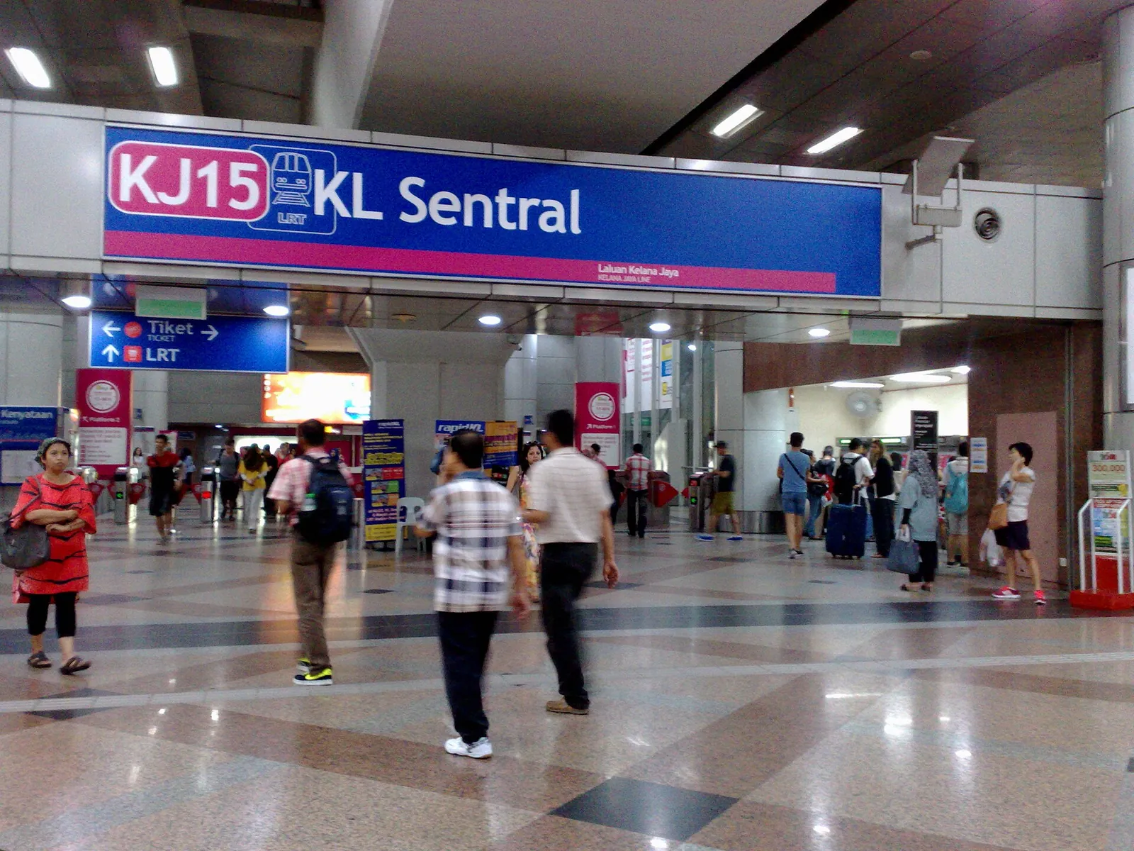 Passengers beneath a KL Sentral sign at the LRT station entrance