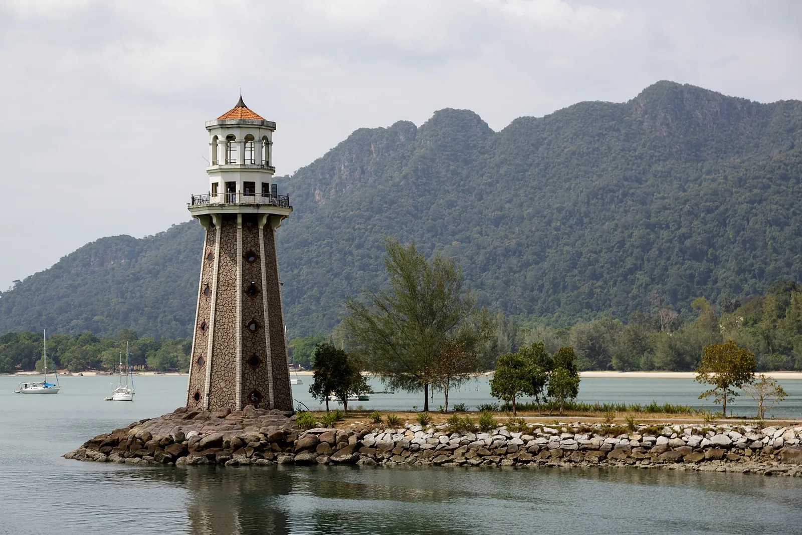 Maják Pantai Kok s pohořím Machinchang v pozadí