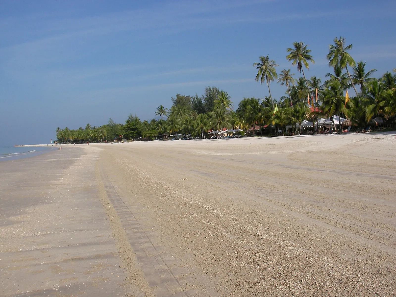 Písečná pláž s palmami v Pantai Cenang na Langkawi