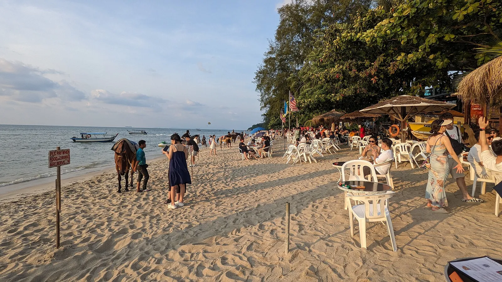 Strandstole og besøgende på Batu Ferringhi-stranden i Penang