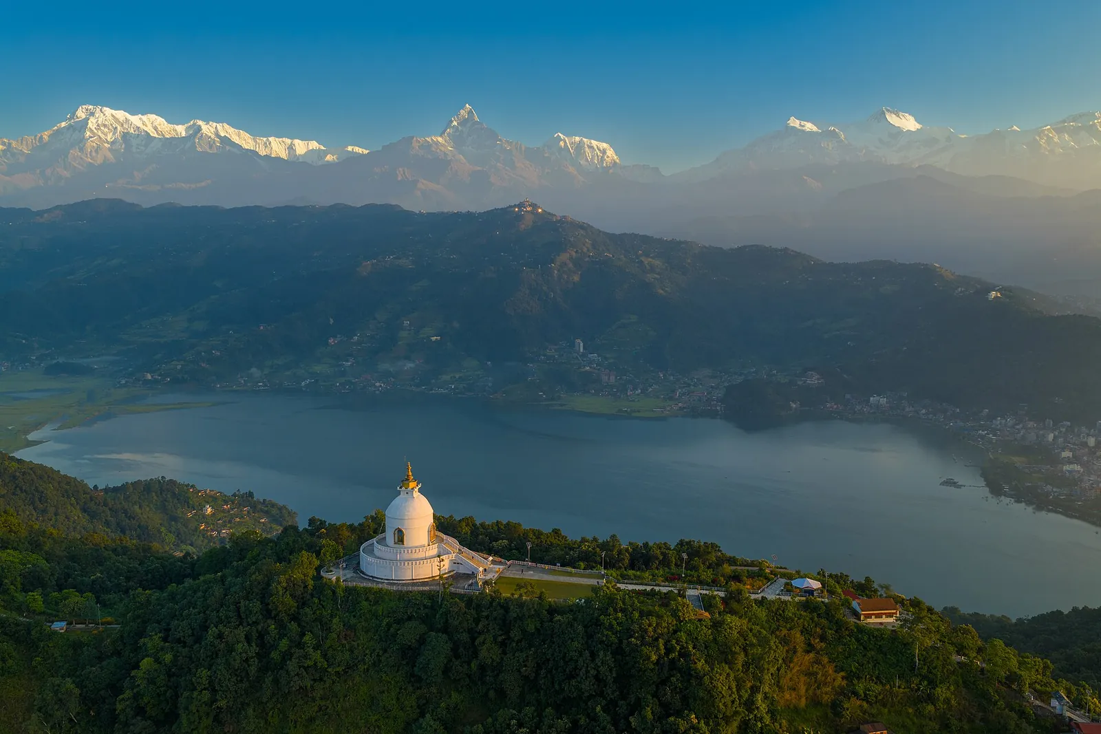 Pagoda blanca de la Paz Mundial sobre el lago Phewa, con el valle de Pokhara y lejanas cumbres nevadas al fondo