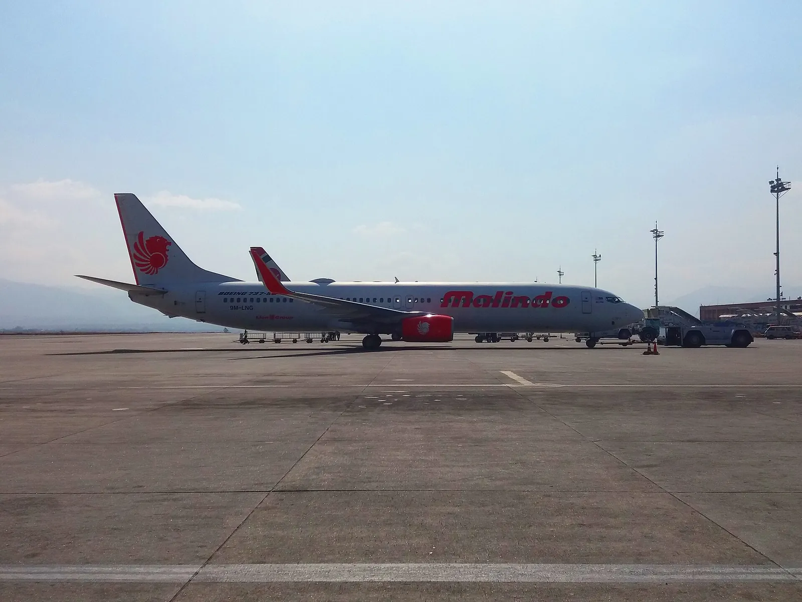 Proudové letadlo Malindo Air zaparkované za jasného dne na odbavovací ploše mezinárodního letiště Tribhuvan