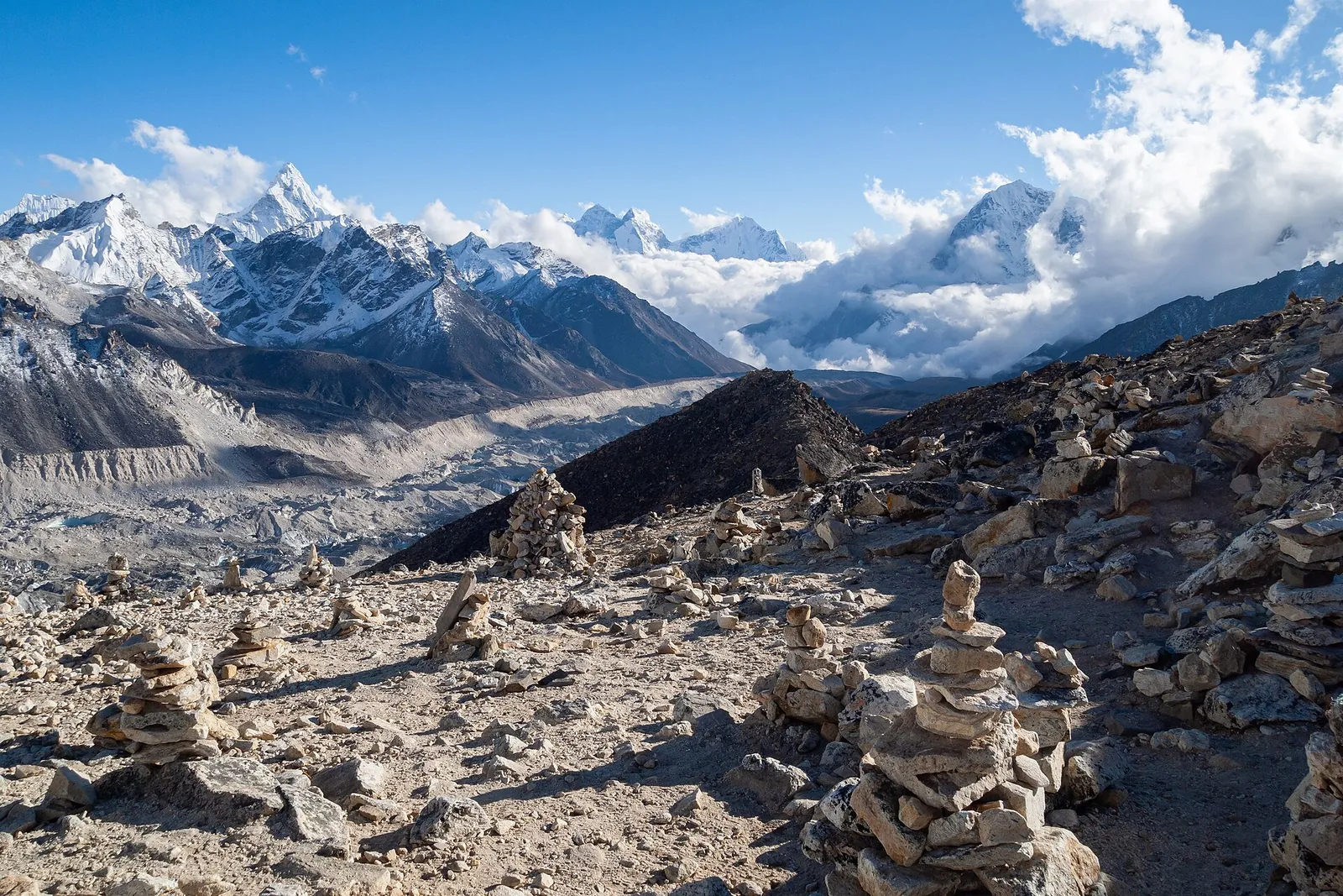 Havas csúcsok és a Khumbu-gleccser az Everest térségében, egy magas gerincről nézve, kék ég alatt