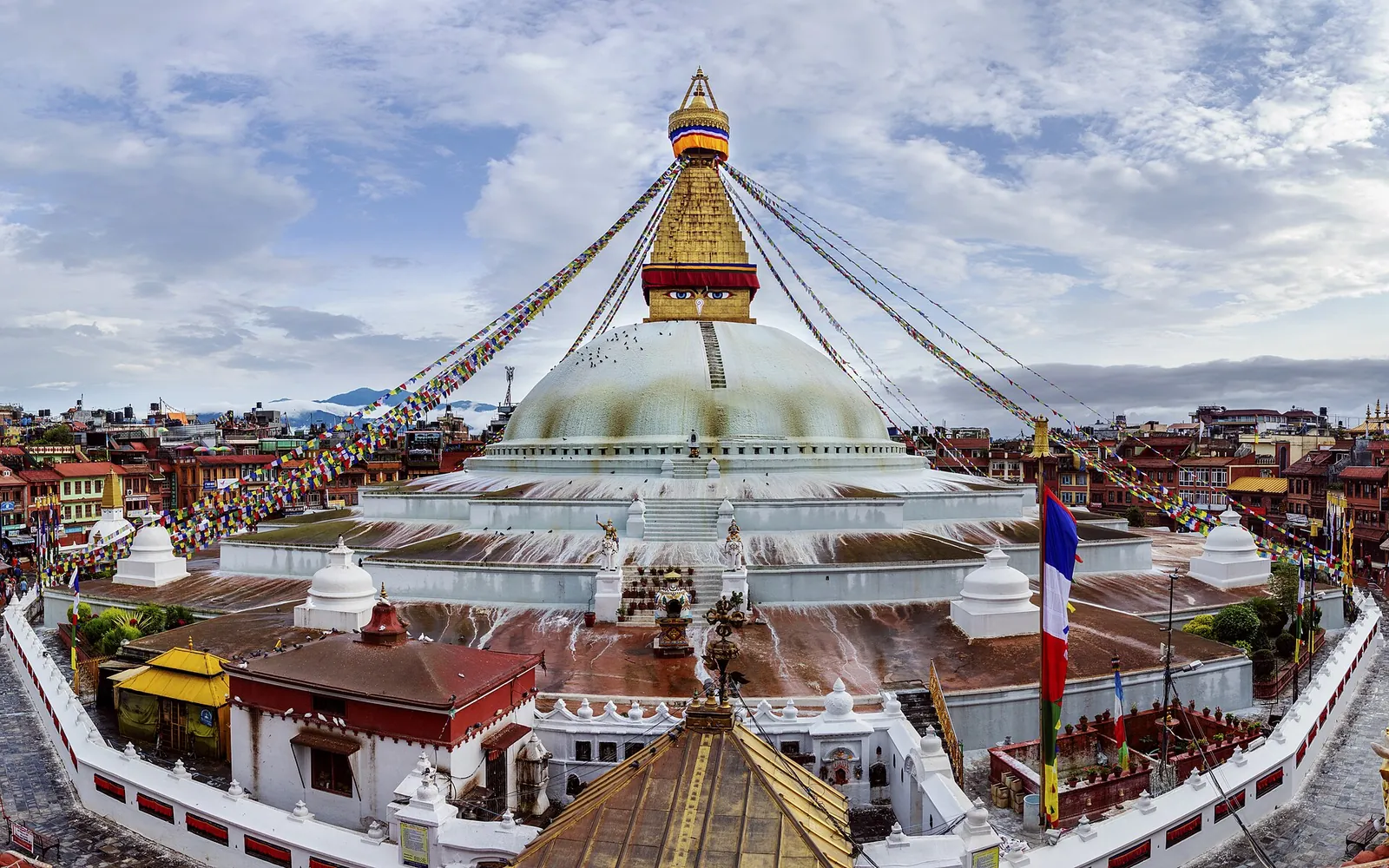 La estupa de Boudhanath vista desde arriba, con su aguja dorada, banderas de oración y los tejados que la rodean