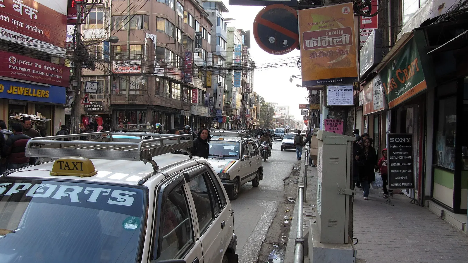 Taksówka z oznaczeniem na dachu w ruchu ulicznym na New Road w Katmandu