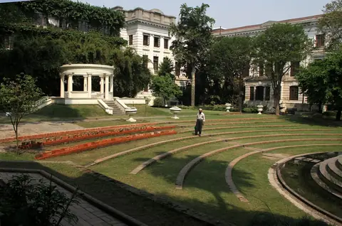 Césped, una terraza ajardinada con forma de anfiteatro y un pabellón blanco en el Jardín de los Sueños, Katmandú