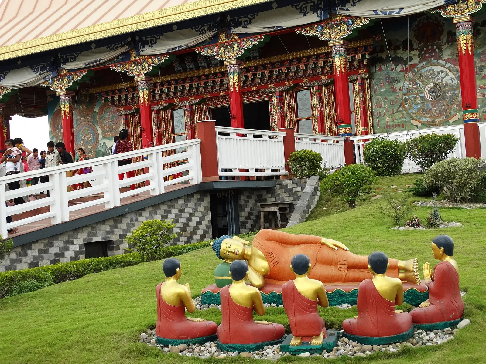 Hagen til Det tyske klosteret i Lumbinis klostersone, med en liggende Buddha-figur og munker