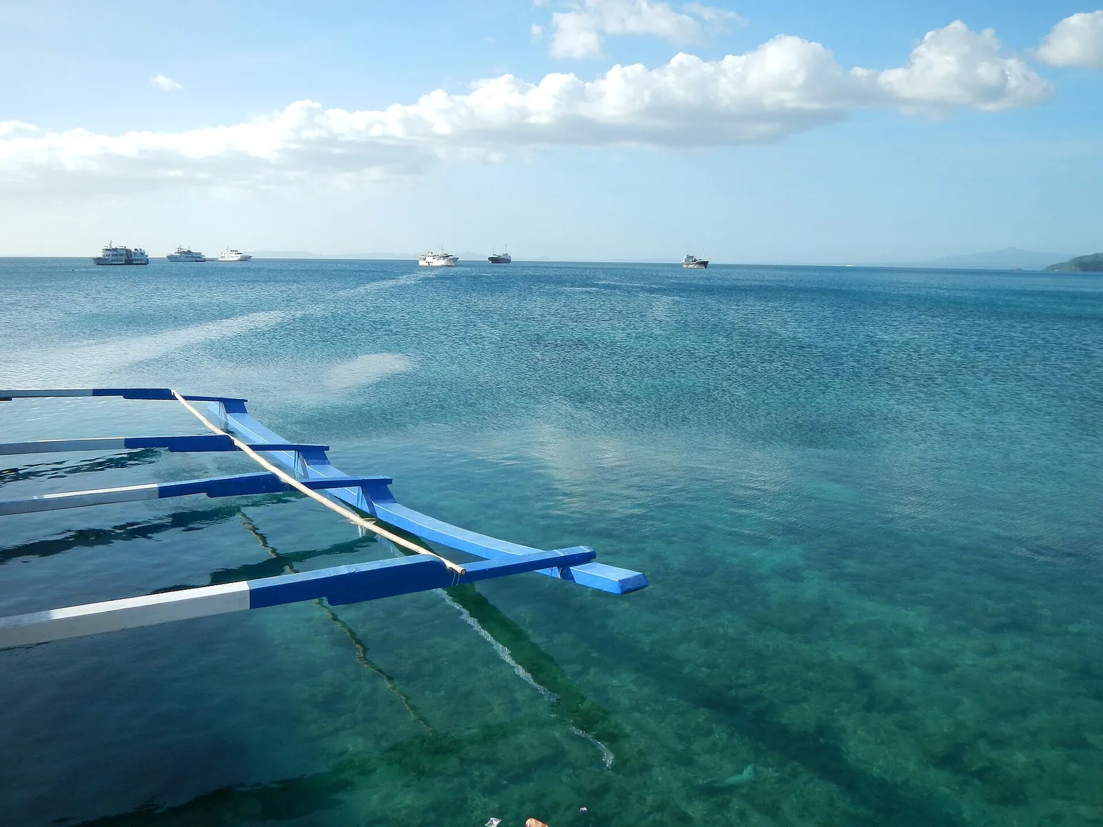 Outrigger boat beams above clear blue water near Anilao in Batangas