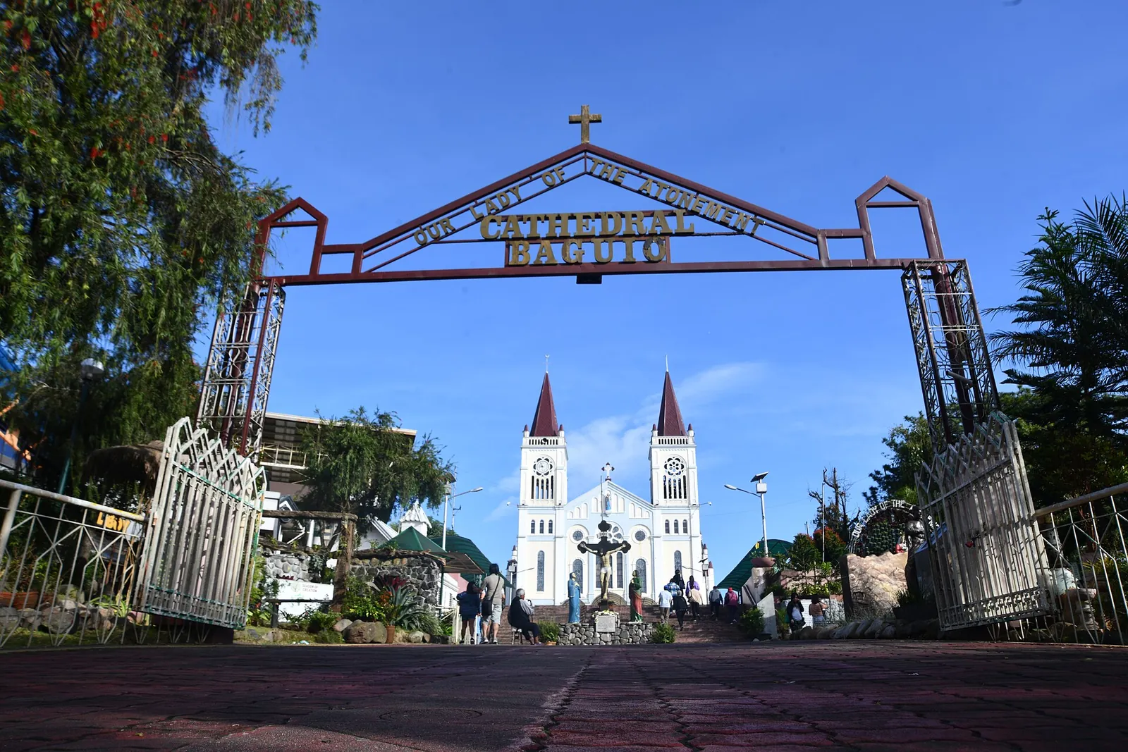 Gateway and twin towers of Baguio Cathedral beneath a blue sky