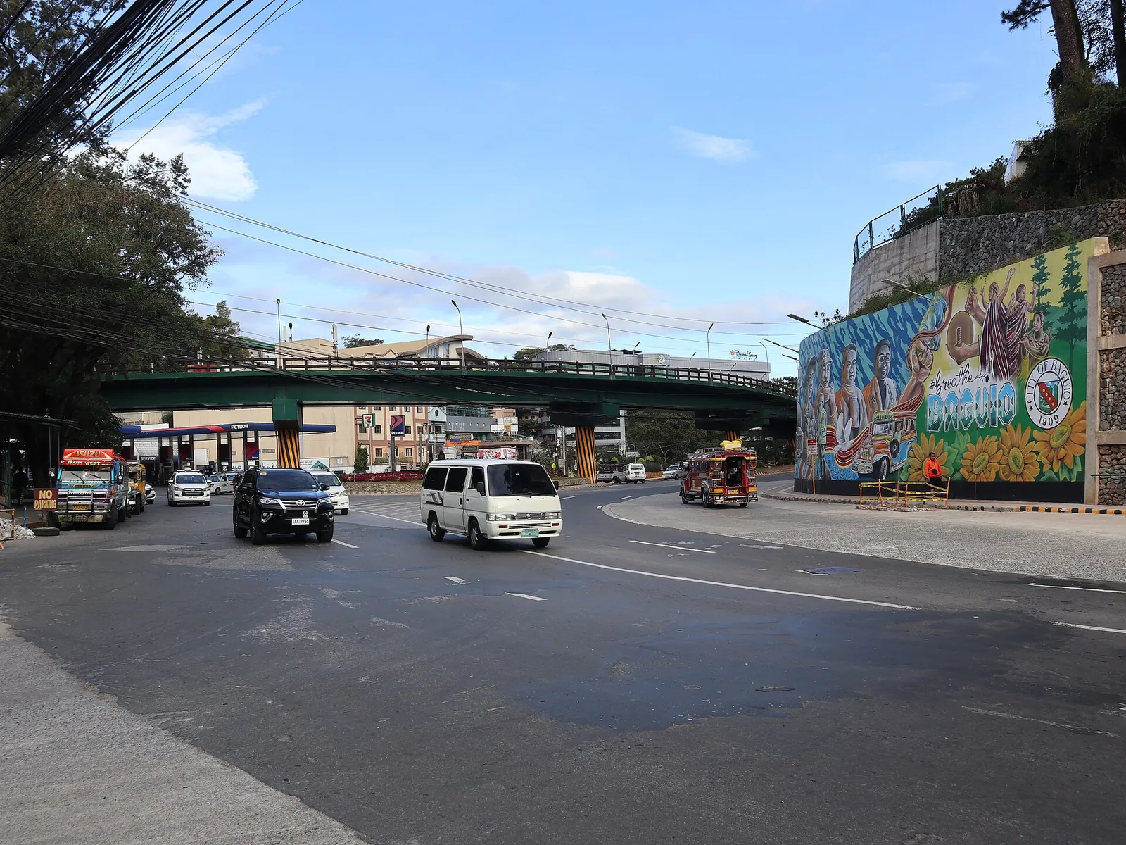 Vehicles beside the BGH flyover and a mural in Baguio