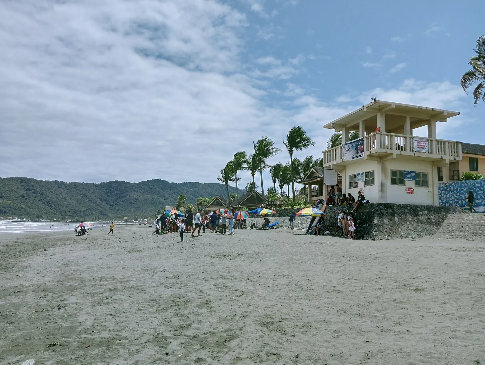 Beachfront buildings and palms beside Sabang Beach in Baler
