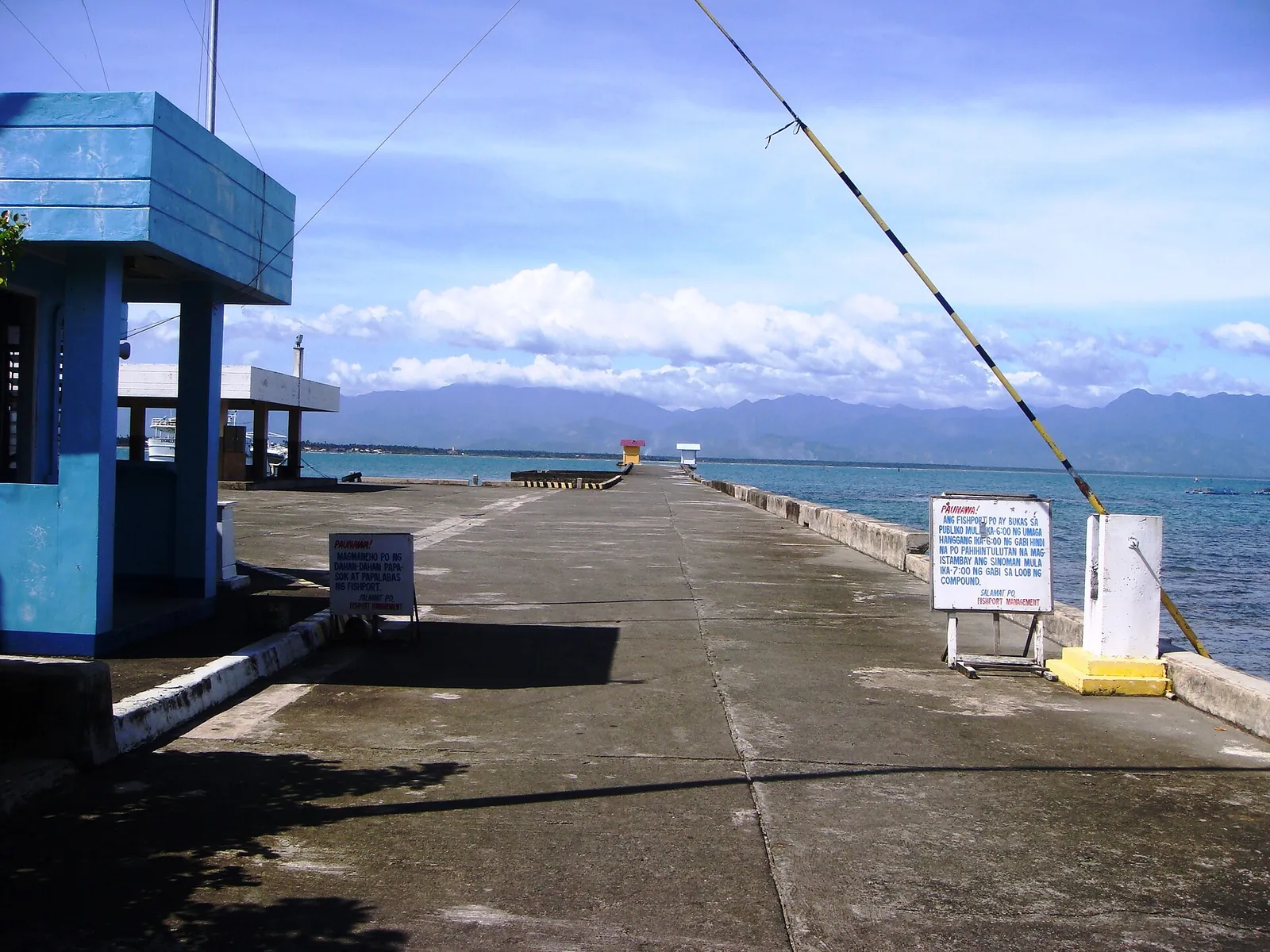 Blue port structure and a pier extending toward the mountains at Baler