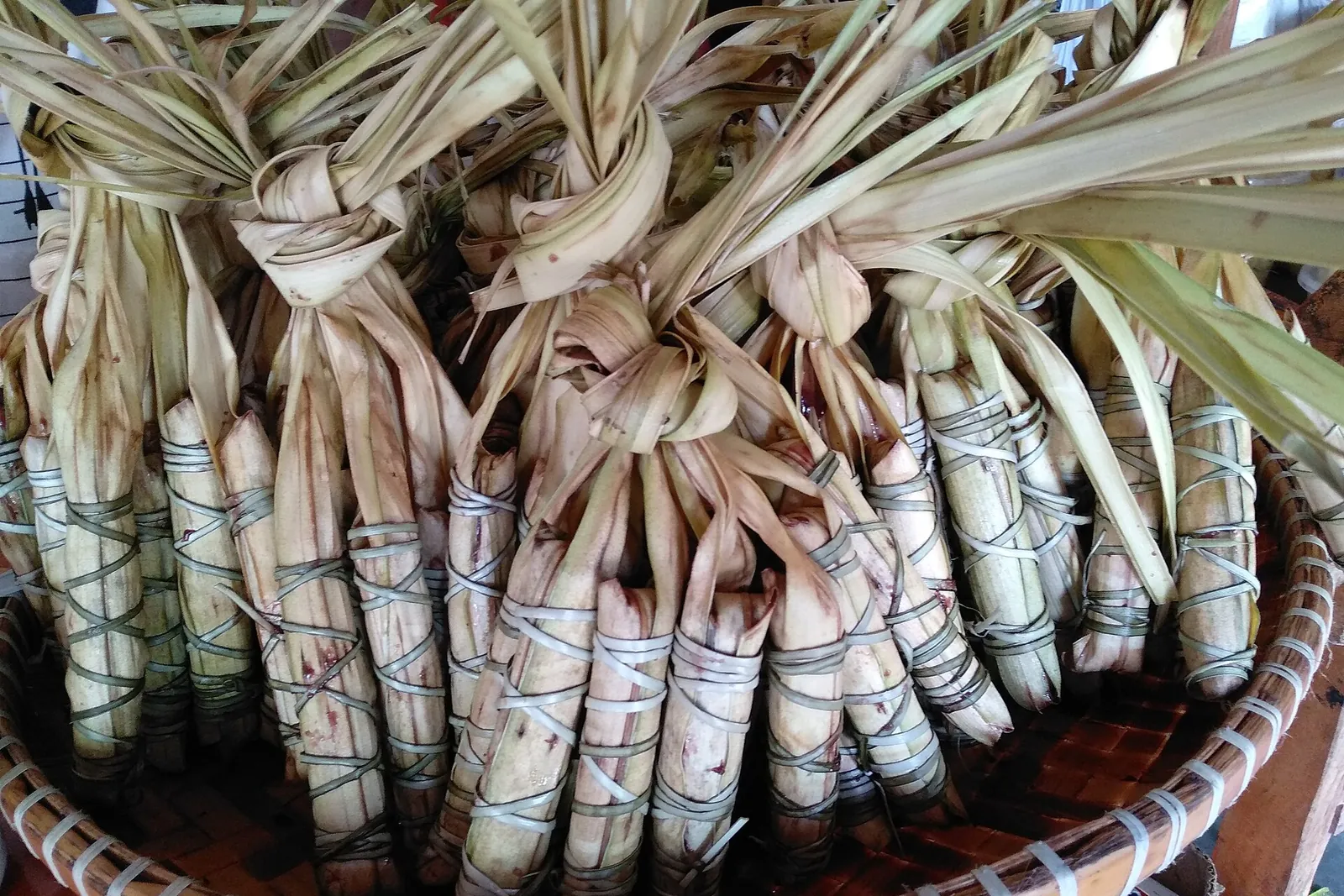 Bundles of leaf-wrapped kakanin arranged in a basket in Baler