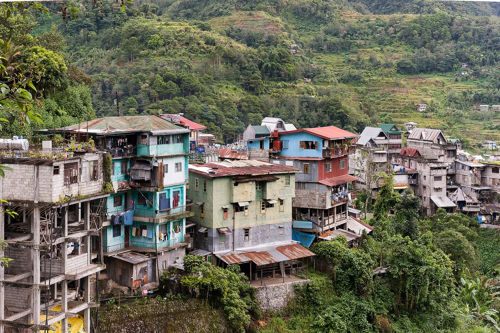 Buildings of Banaue town standing along a wooded hillside
