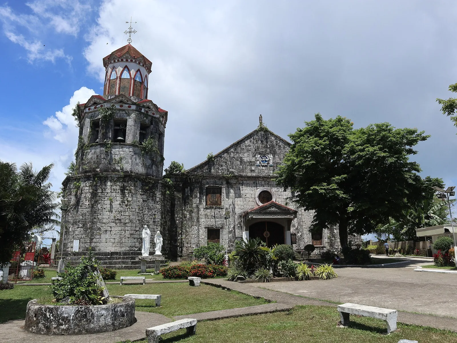 Stone Saint Michael church and bell tower under a blue sky in Basey