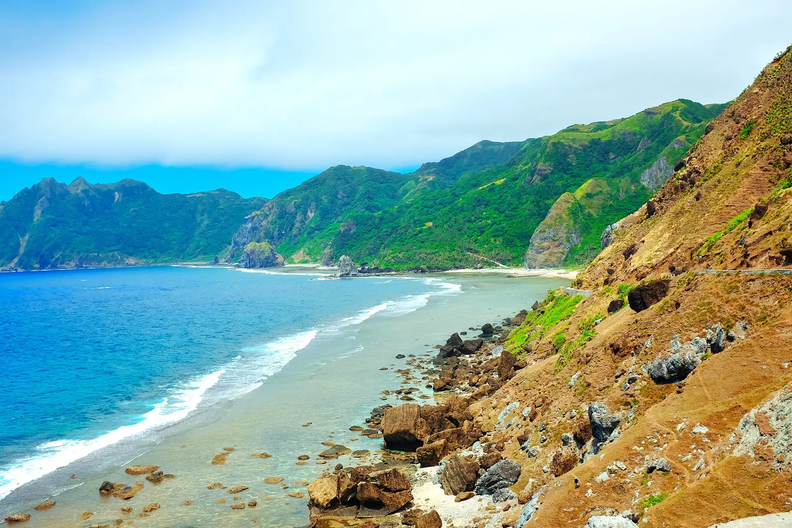 Blue water, cliffs and a narrow shoreline at Chavayan on Sabtang Island in Batanes