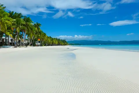 Bílý písek, palmy a modré moře na White Beach na Boracay